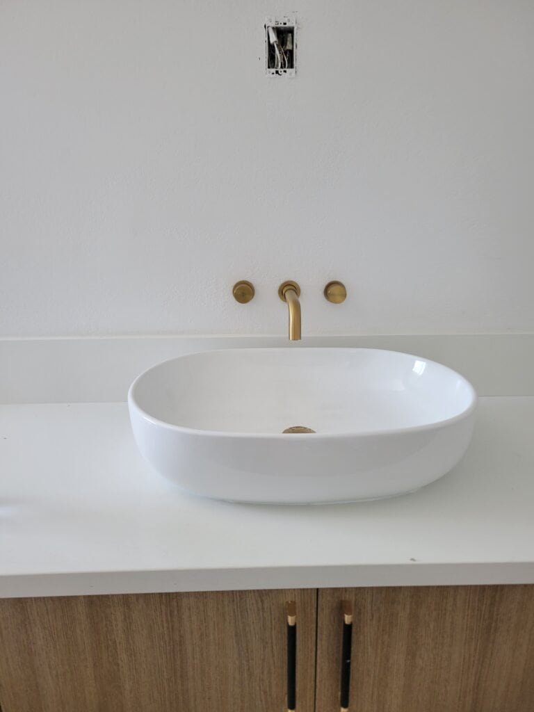 Modern bathroom sink with faucet and wall plumbing fixtures, ready for installation.