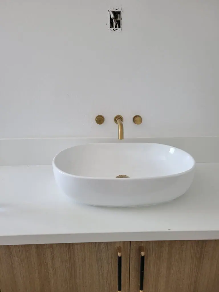 Modern bathroom sink with faucet and wall plumbing fixtures, ready for installation.