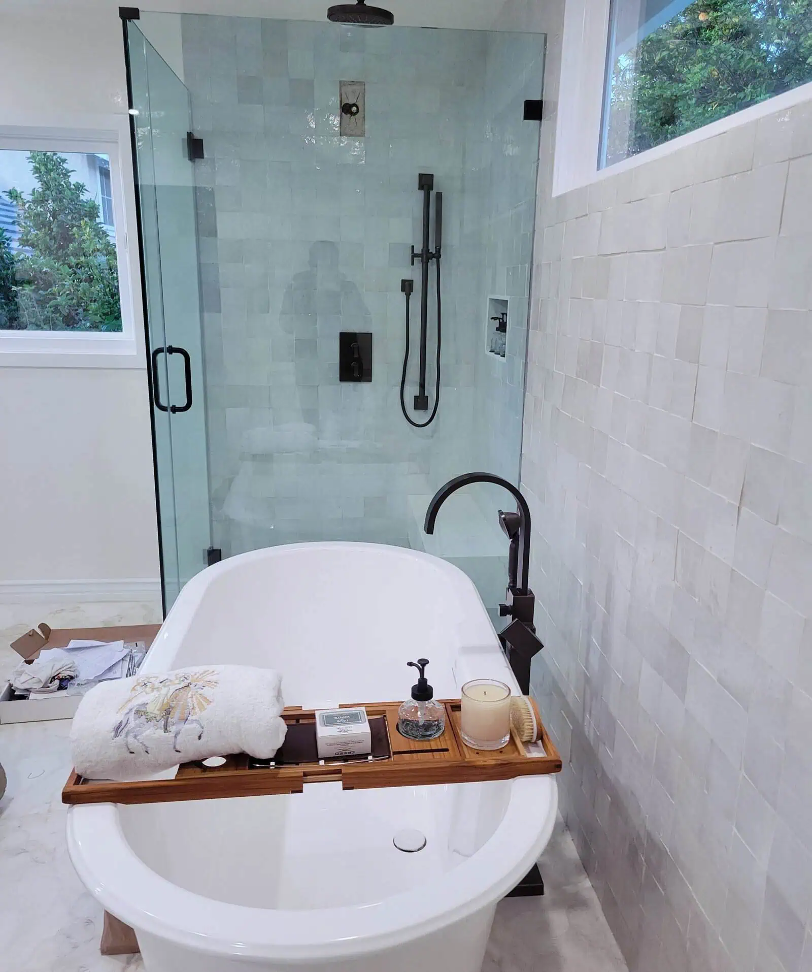 Modern bathroom with walk-in shower and bathtub, plumbing fixtures, and natural light.