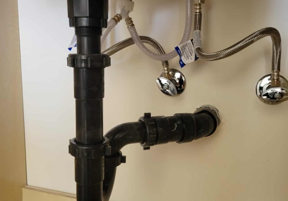 Under sink plumbing pipe with shut-off valves and flexible hoses.